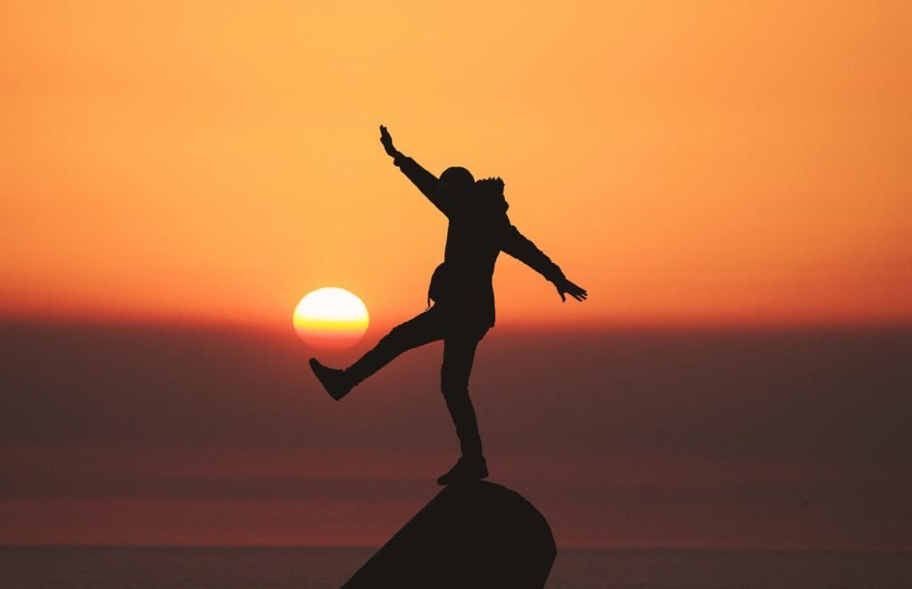 | Chill & Thrive a man standing on a rock, sunset