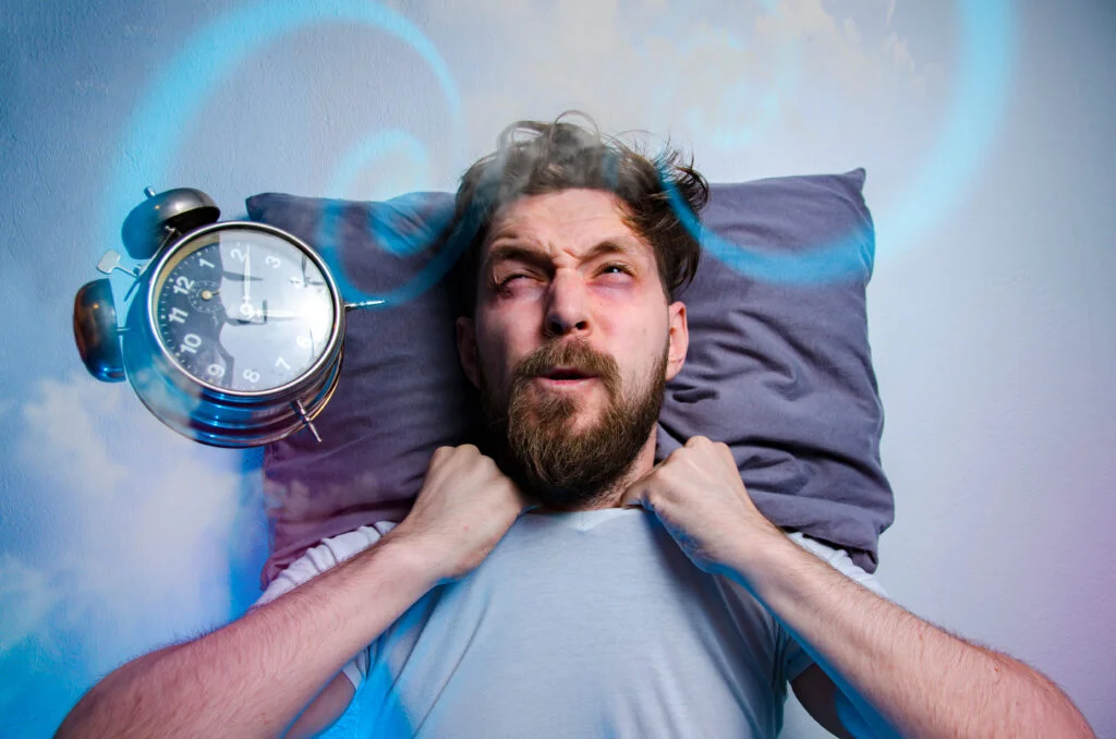 Mad man having trouble sleeping insomnia concept alarm clock flying in front of his head | Chill & Thrive | Chill & Thrive Mad man having trouble sleeping insomnia concept alarm clock flying in front of his head