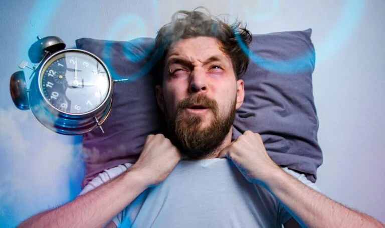 Mad man having trouble sleeping insomnia concept alarm clock flying in front of his head
