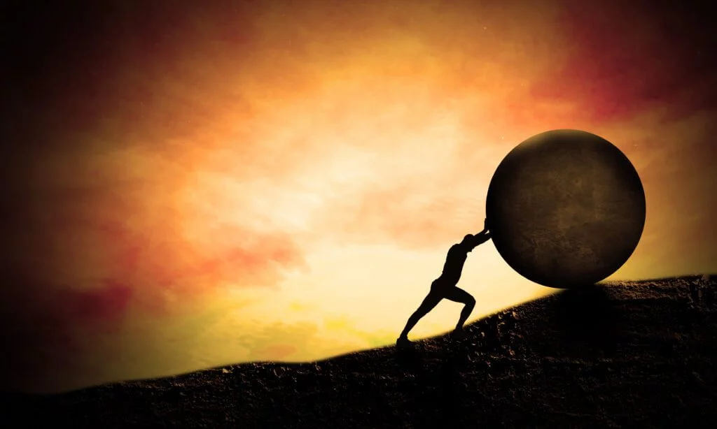 Young Business man Pushing Big stone up to hill. Sunset scene. C | Chill & Thrive | Chill & Thrive Young Business man Pushing Big stone up to hill. Sunset scene. C