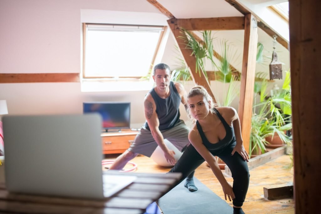 | Chill & Thrive Man and Woman Watching on a Laptop While Working Out