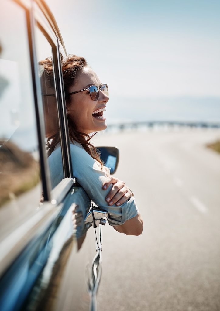 Happy freedom and road trip with a woman in a car looking at the view from the window while on the open road Smile travel and fun with a young female traveler on a journey during her vacation | Chill & Thrive continuous self improvement and happiness