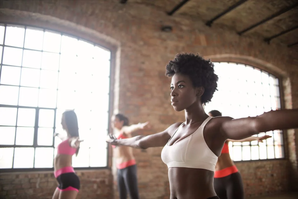 Photo by Andrea Piacquadio | Chill & Thrive | Chill & Thrive Confident fit ethnic woman training with other sportswomen in modern fitness studio